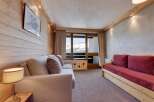 This cozy living space features a warm, inviting atmosphere with its wooden paneling and comfortable seating.