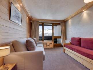 This cozy living space features a warm, inviting atmosphere with its wooden paneling and comfortable seating.