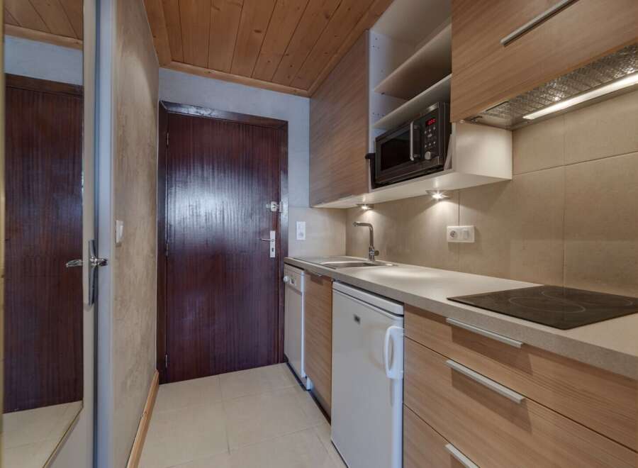 Discover this charming studio apartment featuring a well-equipped kitchenette, perfect for preparing meals.