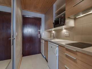 Discover this charming studio apartment featuring a well-equipped kitchenette, perfect for preparing meals.