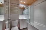 This charming bathroom features a clean and modern design with white tiles and a wooden ceiling.