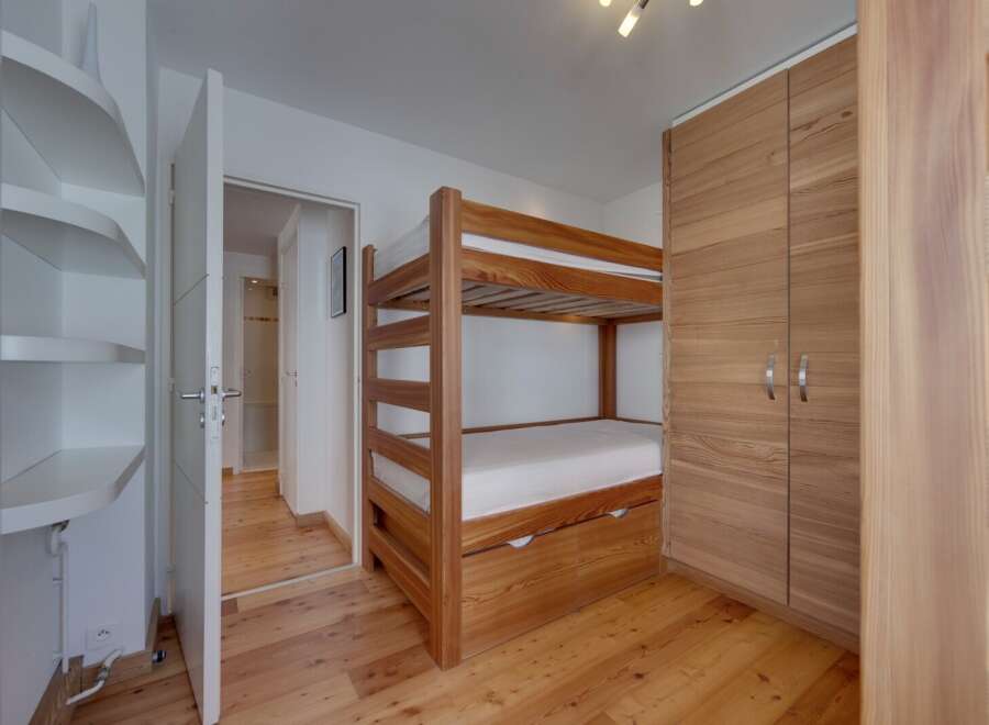 Discover this cozy bedroom featuring a charming bunk bed, perfect for accommodating guests or family.