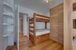 Discover this cozy bedroom featuring a charming bunk bed, perfect for accommodating guests or family.