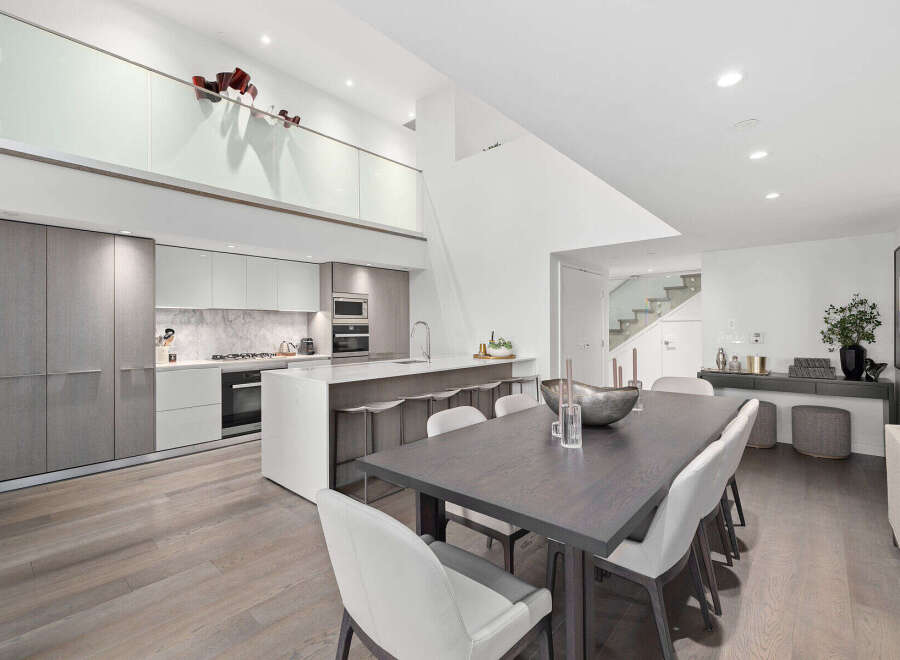 This stunning modern kitchen and dining area boasts a sleek design with high-end finishes.