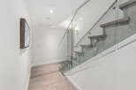 This stunning property features a modern staircase with glass railings, creating an open and airy feel.