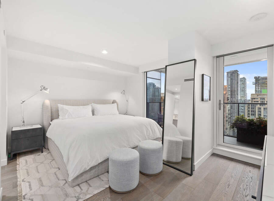 Experience luxury living in this stunning bedroom with breathtaking city views.
