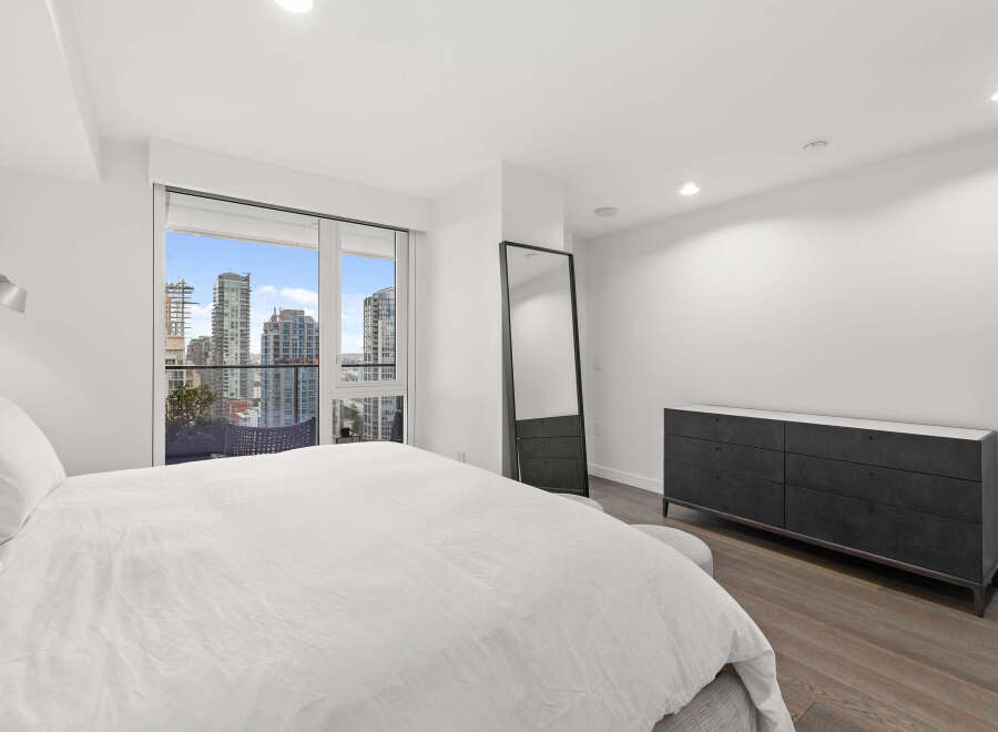 Experience luxury living in this stunning bedroom with breathtaking city views.