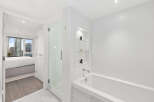 Step into luxury with this stunning bathroom, featuring a sleek glass shower and a relaxing bathtub.