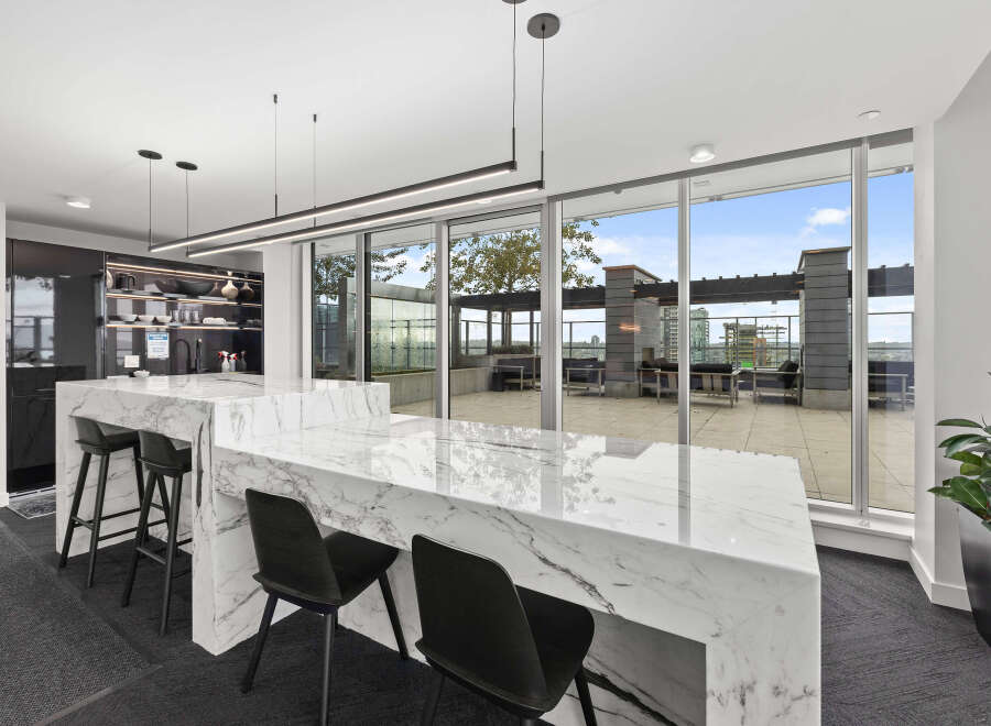 Experience luxury living in this stunning property featuring a modern kitchen with sleek marble countertops and stylish seating.