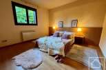 Discover the charm of this cozy bedroom, featuring a comfortable bed with plush pillows and a warm, inviting ambiance.