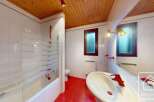 This charming bathroom features a unique combination of red tile flooring and a wooden ceiling, creating a warm and inviting atmosphere.