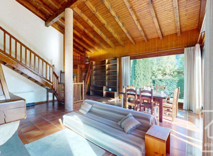 Discover the charm of this inviting property, featuring a warm wooden ceiling and a cozy living space.