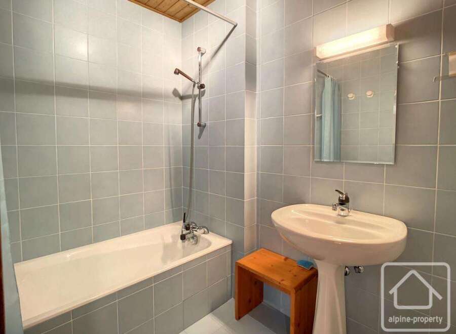 This bathroom features a bathtub and a pedestal sink, offering a functional and classic design.