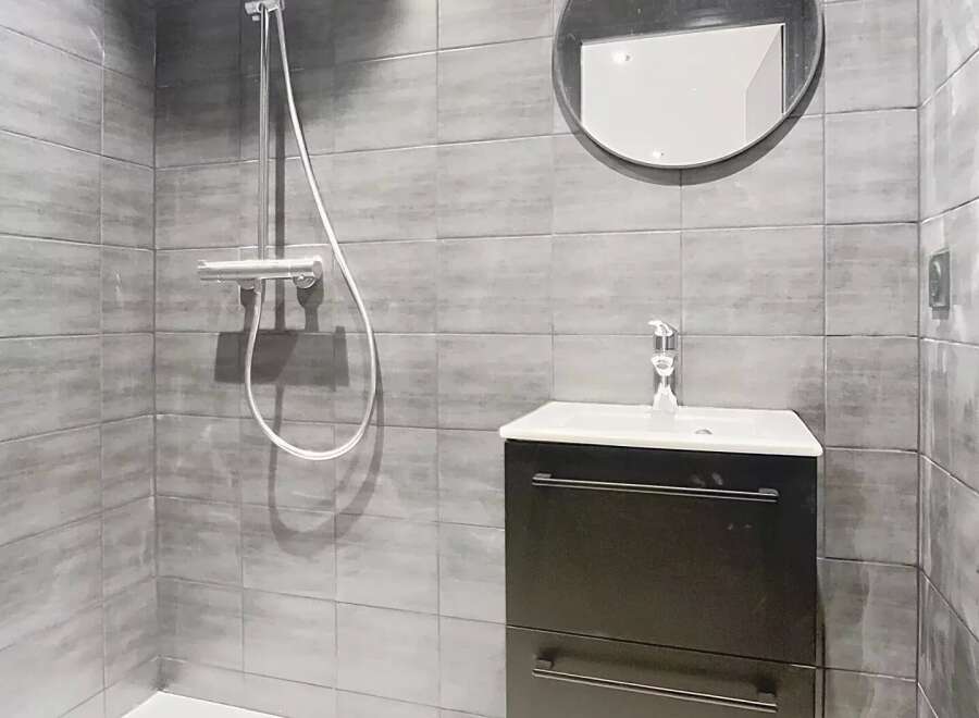 This modern bathroom features sleek gray tiles and a minimalist design.