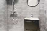 This modern bathroom features sleek gray tiles and a minimalist design.