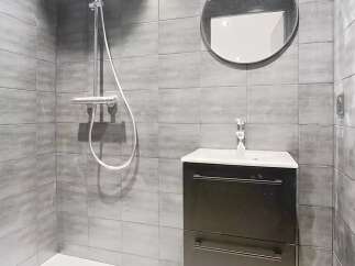 This modern bathroom features sleek gray tiles and a minimalist design.