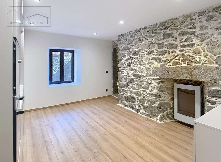 Discover the charm of this unique property featuring a stunning stone wall that adds character and warmth to the space.