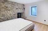 Discover the charm of this unique bedroom featuring a stunning stone wall that adds character and warmth.
