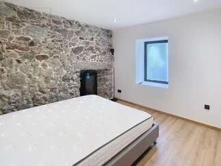 Discover the charm of this unique bedroom featuring a stunning stone wall that adds character and warmth.