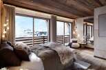 Experience the epitome of luxury in this stunning bedroom, boasting breathtaking views of a snow-covered landscape.