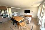 This modern living space features a stylish dining area with a wooden table and chairs, perfect for family meals or entertaining guests.