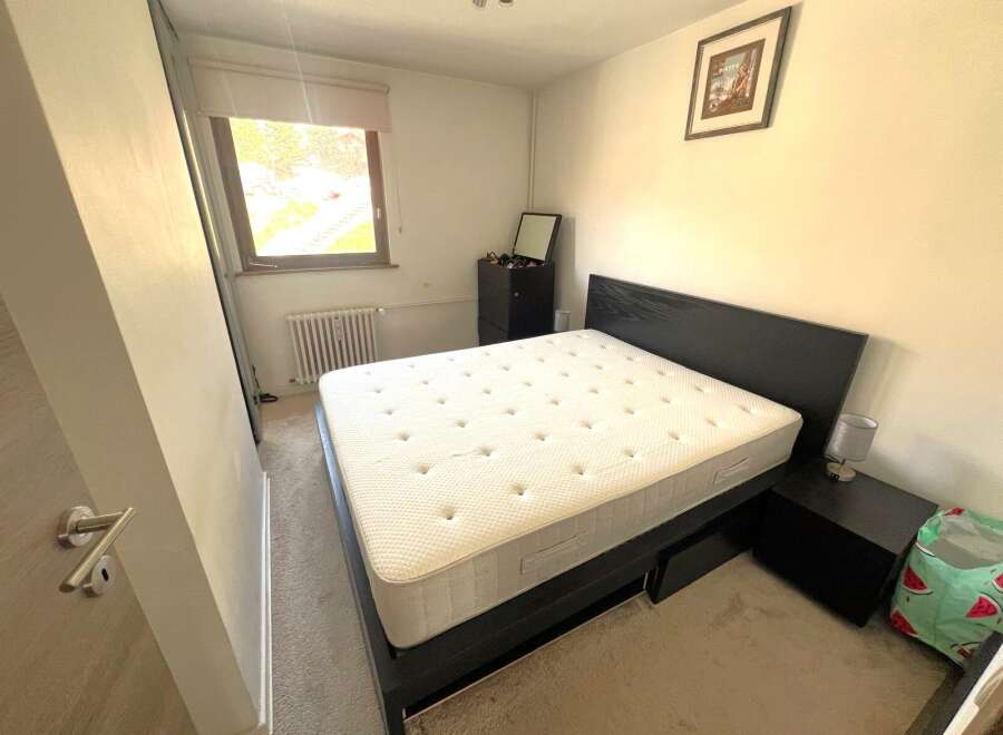 Discover this cozy bedroom featuring a comfortable bed and a stylish nightstand.