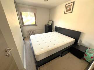 Discover this cozy bedroom featuring a comfortable bed and a stylish nightstand.