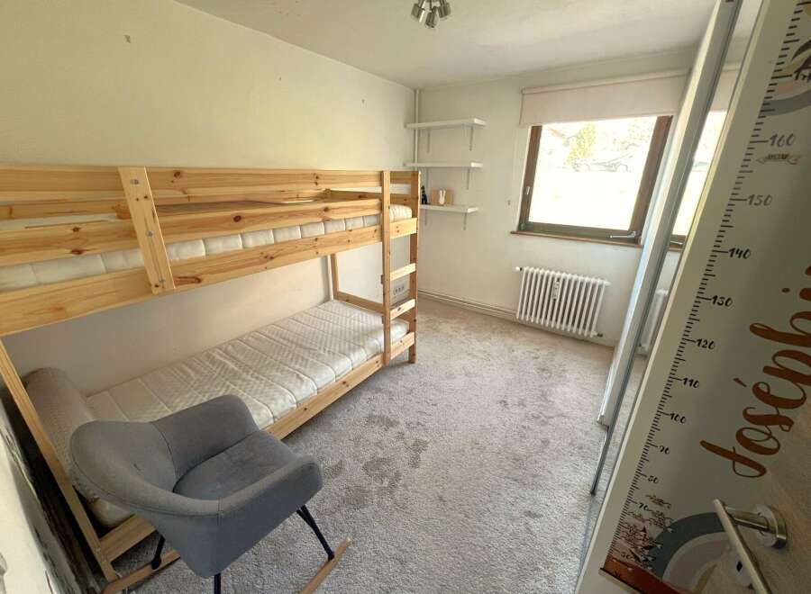 This charming bedroom features a cozy bunk bed, perfect for kids or guests.