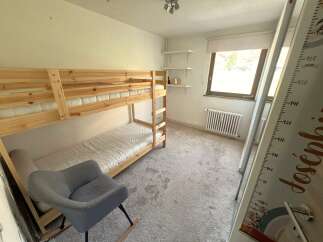 This charming bedroom features a cozy bunk bed, perfect for kids or guests.