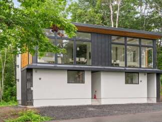 This modern home boasts a sleek design with large windows offering stunning views.
