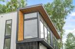 This stunning modern home boasts a striking architectural design with a combination of wood and sleek black accents.