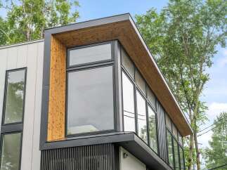 This stunning modern home boasts a striking architectural design with a combination of wood and sleek black accents.