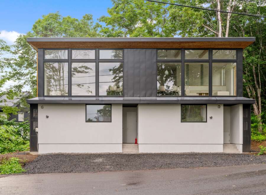 This modern home boasts a sleek design with expansive windows that flood the interior with natural light.