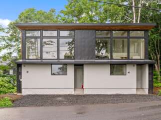 This modern home boasts a sleek design with expansive windows that flood the interior with natural light.