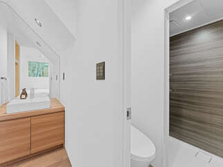 This modern bathroom features a sleek design with a wooden vanity and a minimalist sink.