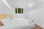 This modern bedroom offers a serene retreat with its minimalist design and bright, airy ambiance.