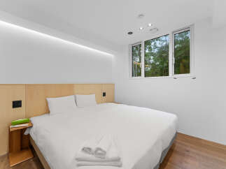 Experience tranquility in this modern bedroom, featuring a comfortable bed and a serene ambiance.