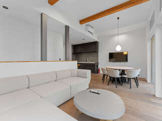 This modern living space features a sleek, white sectional sofa and a stylish round coffee table, perfect for relaxation and entertaining.