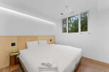 Experience tranquility in this modern bedroom, featuring a comfortable bed and a serene ambiance.