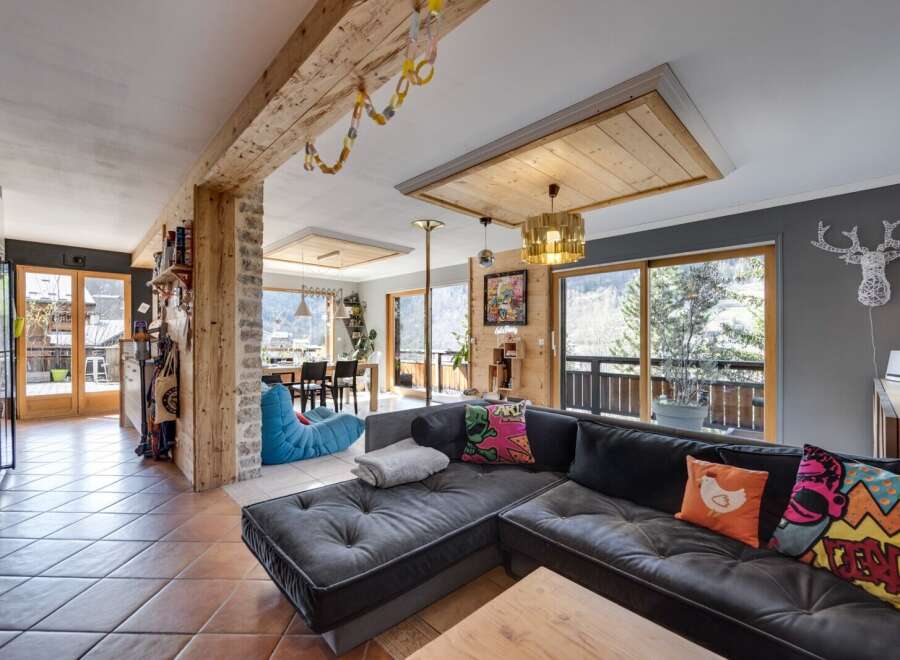 This stunning property boasts a spacious living area with a modern, L-shaped sofa, perfect for relaxing.