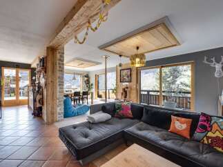 This stunning property boasts a spacious living area with a modern, L-shaped sofa, perfect for relaxing.