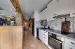 This stunning kitchen boasts a modern design with sleek white cabinetry and a stylish backsplash.