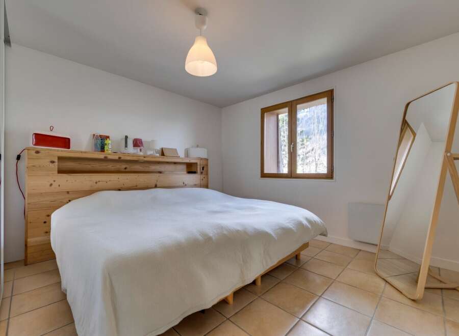 This cozy bedroom features a comfortable bed with a wooden headboard, creating a warm and inviting atmosphere.