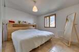 This cozy bedroom features a comfortable bed with a wooden headboard, creating a warm and inviting atmosphere.