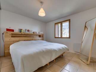 This cozy bedroom features a comfortable bed with a wooden headboard, creating a warm and inviting atmosphere.
