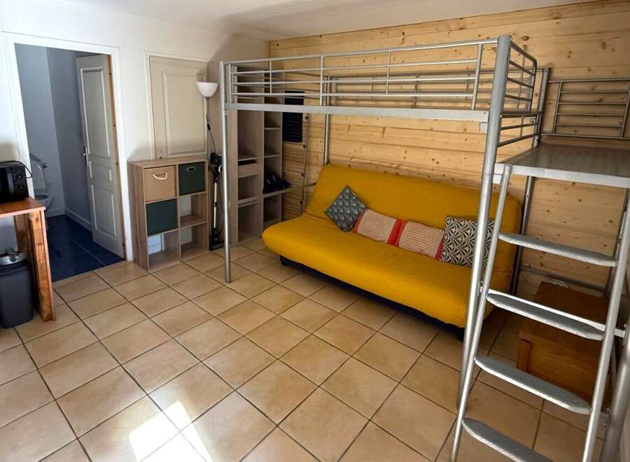 This cozy studio apartment features a unique loft bed, maximizing space and offering a modern living experience.