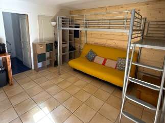 This cozy studio apartment features a unique loft bed, maximizing space and offering a modern living experience.