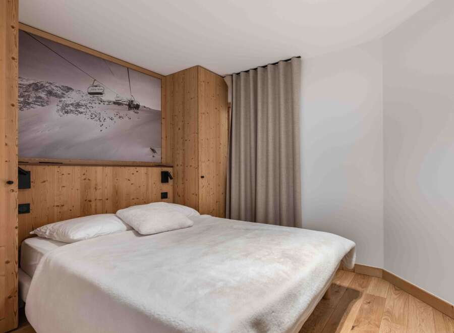 Experience the cozy charm of this bedroom, featuring a unique mountain-themed wall art that adds a touch of adventure.
