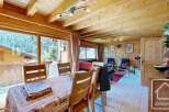Experience the charm of this stunning property, featuring a warm and inviting interior with exposed wooden beams and paneling.
