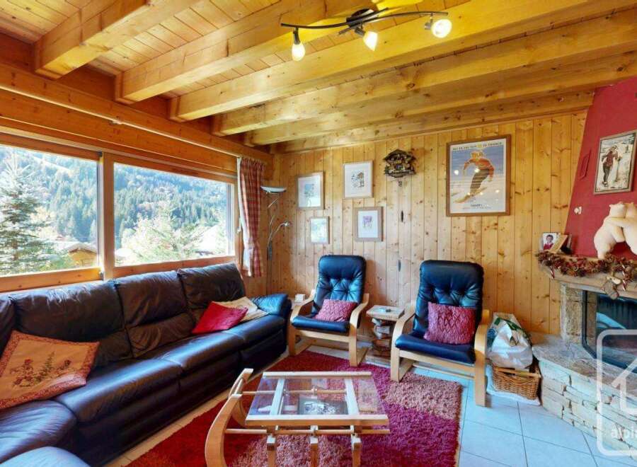 This cozy living room features a stunning view of the surrounding mountains, perfect for a relaxing getaway.
